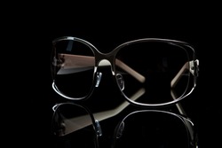 Elegant sunglasses on black background