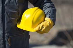 hand of worker with yellow hard-hat,natural light