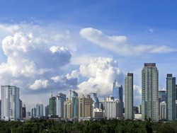 Makati skyline shot against blue sky and swirling clouds