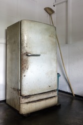 Dilapidated, dirty and rusty vintage refrigerator