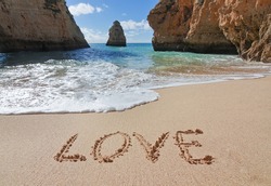 Word love in the sand at the beach on Valentine Day.