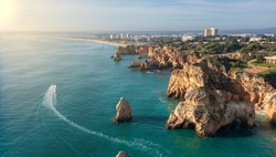 Aerial view of beautiful Portuguese beaches with rocky sandy shores and pure sand for tourists recreation in the Algarve in the south. Sunny day