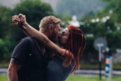 beautiful couple kissing outside in the rain