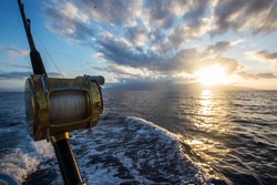 Deep Sea Fishing Reel on a boat during sunrise 