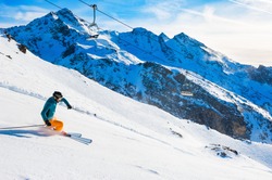 Skier rides down the slope in Alps mountains. Winter sport. Val Thorens, 3 Valleys, France. Beautiful mountains, winter landscape
