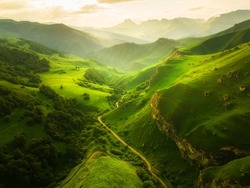 View of the green mountains and hills at sunset. Beautiful summer landscape. Aktoprak Pass in North Caucasus, Russia. 