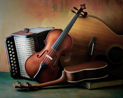 Acoustic musical instruments guitar ukulele violin and accordion with vintage book lay on fine painted floor and backdrop for wall web interior decoration still life style