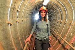 Motion blur of adult Australian woman (female age 30-40) descending into an underground  tunnel.