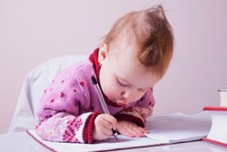 little beautiful child girl learns to write (preschool, development, training, education concept)