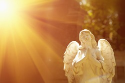 wonderful angel in the rays of the sun (architecture, statue, archetype, religion, faith concept)