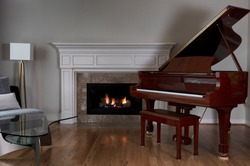 Glowing fireplace with baby grand piano on solid red oak floors  