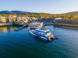 Whale watch ship aerial view docked at pier at sunset in historic town center of Bar Harbor on Mt Desert Island, Maine ME, USA. 