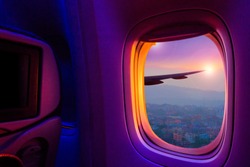 Beautiful scenic city view of sunset through the aircraft window. Image save-path for window of airplane.