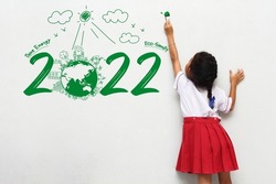 Asian little girl holding a paint brush painting creative environmental and eco-friendly, Save energy 2022 new year