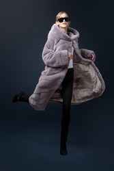 A full length portrait of a young fashionable woman in a grey mink coat. Beauty, fashion.