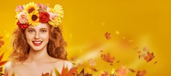 Portrait of a beautiful young woman with long curly red hair and in a wreath of flowers posing on a yellow background with maple leaves. Autumn beauty. Make-up and cosmetics. Copy space.