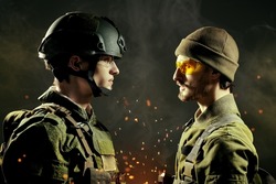 Military conflict. Two brave soldiers in Protective Combat Uniform stand face-to-face looking seriously at each other. Dark background with smoke and sparks of fire. War concept. 