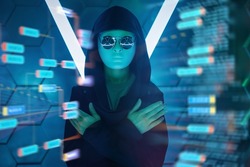 Cyberspace. A portrait of a mysterious teenage boy in a black clothes, mask and black sunglasses looking through holographic data. Teen boy hacker.