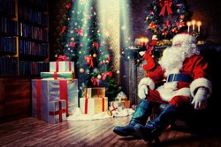 Santa Claus brought gifts for Christmas and having a rest by the fireplace. Home decoration.