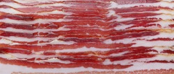 Pancetta. Close up of Italian pancetta cut into slices. Cured meat product. Food background. Panoramic macro image. Hi-res banner.