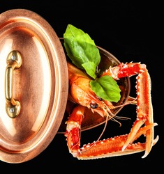 A cooked lobster being lifted from a pot in the kitchen.