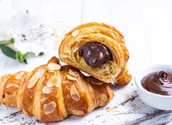Yummy freshly croissant, sliced almonds, with chocolate filling cut, close up