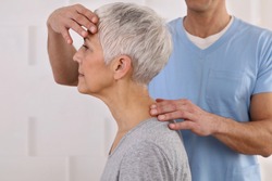 Mature Woman having chiropractic adjustment. Osteopathy, Physiotherapy, acupressure, holistic care. Craniosacral therapy