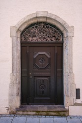 Artfully crafted round-arched door in a historic edifice on Manghaus Square in the Old Town of Memmingen in the Lower Allgäu region of Swabia, Bavaria, Germany.