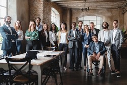 Corporate portrait of a multigenerational working team with multiracial and disabled members - Group photo of colleagues standing in the office in co-working space looking at the camera - lifestyle