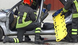 firefighters in action during the rescue of the injured after the car accident with the stretcher to transport the injured