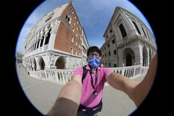 young tourist with surgical mask photographed in Venice without other people during the lockdown in Italy