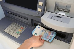 hand who picks up european 20 Euro bills in an ATM of the bank