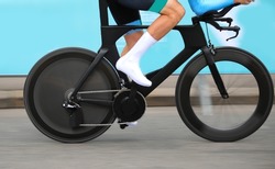 racing bicycle with speed lenticular wheel with cyclist engaging in pedaling
