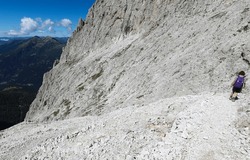Young female hiker descends from Monte ROSETTA near SAN MARTINO DI CASTROZZA on the Euopean alps in Northern Italy in summer