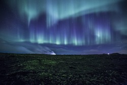 Colorful aurora over a mossy Icelandic lava field 