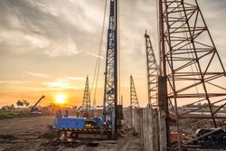 pile crane in construction site at sunset
