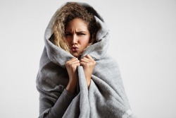 woman feeling freeze and wrap up in a blanket