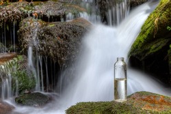 A bottle of drinking water stands on a stone in front of a waterfall. Will we run out of water soon? By the middle of the century the demand for water will increase by around 55 percent worldwide.