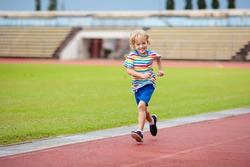Child running in stadium. Kids run on outdoor track. Healthy sport activity for children. Little boy at athletics competition race. Young athlete in training. Runner exercising. Jogging for kid.