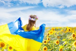 Pray for Ukraine. Child with Ukrainian flag in sunflower field. Little girl waving national flag praying for peace. Happy kid celebrating Independence Day.