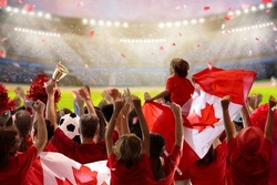 Canada football supporter on stadium. Canadian fans on soccer pitch watching team play. Group of supporters with flag and national jersey cheering for Canada. Championship game.