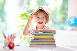 Kids go back to school. Children study and learn for preschool. Little boy of elementary class doing homework. Bedroom with desk, books and globe for young child. Kid learning to read and write.