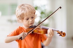 Child playing violin. Remote learning from home. Arts for kids. Little boy with musical instrument. Video chat conference lesson. Online music tuition. Creative children play song. Classical education