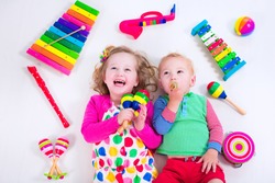Child with music instruments. Musical education for kids. Colorful wooden art toys for kids. Little girl and boy play music. Kid with xylophone, guitar, flute.