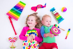 Child with music instruments. Musical education for kids. Colorful wooden art toys for kids. Little girl and boy play music. Kid with xylophone, guitar, flute.