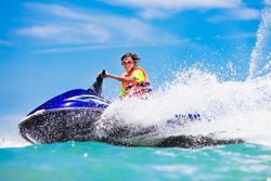 Teenager on water scooter. Teen age boy skiing. Young man on personal watercraft in tropical sea. Active summer vacation for school child. Sport and ocean activity on beach holiday.