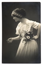 young woman posing with daisy flowers. vintage picture from 1913