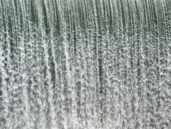 a curtain of water falling over a dam
