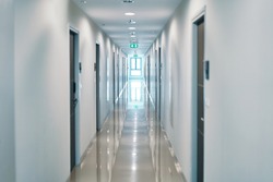 Illuminated long empty corridor in modern building                         