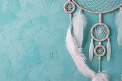 Mint cream dream catcher on turquoise textured background. Texture of concrete. 
